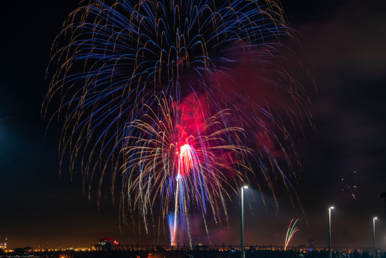 large colorful red fireworks over the Huntington Beach Pier